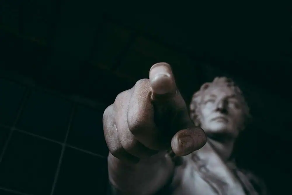 estatua d'home assenyalant la càmera
